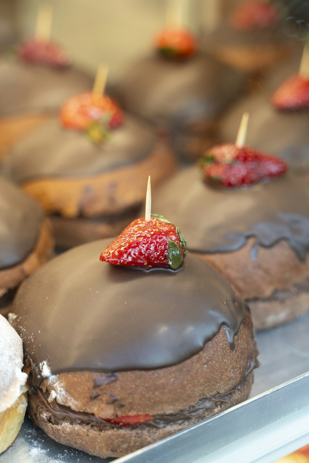 chocolate covered donuts with a strawberry on top