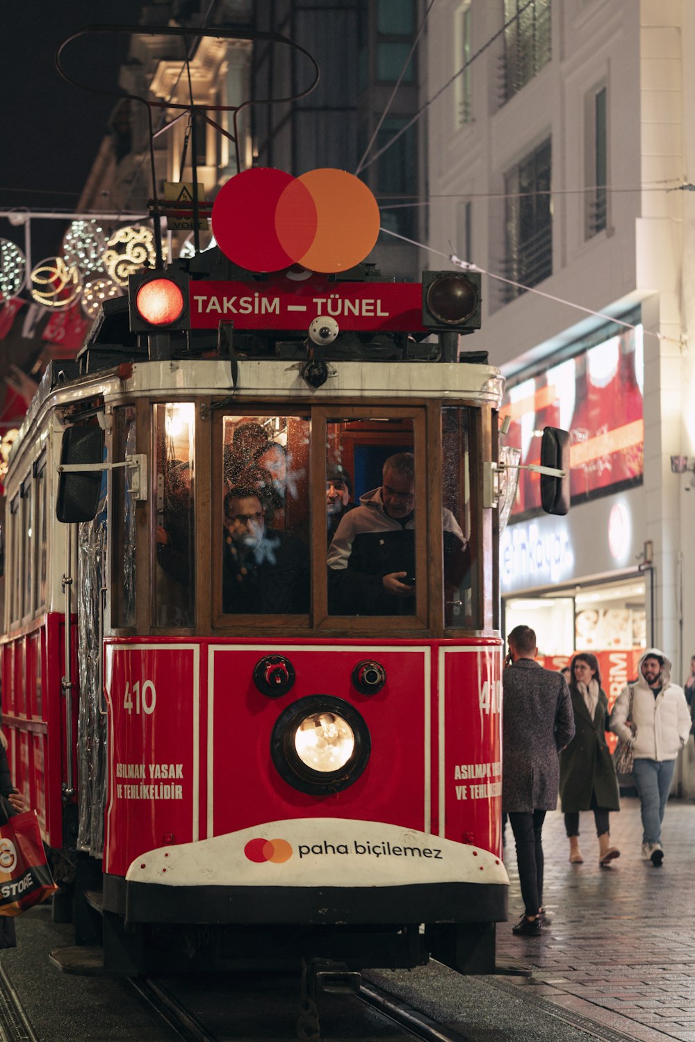 a red and white trolley on a city street