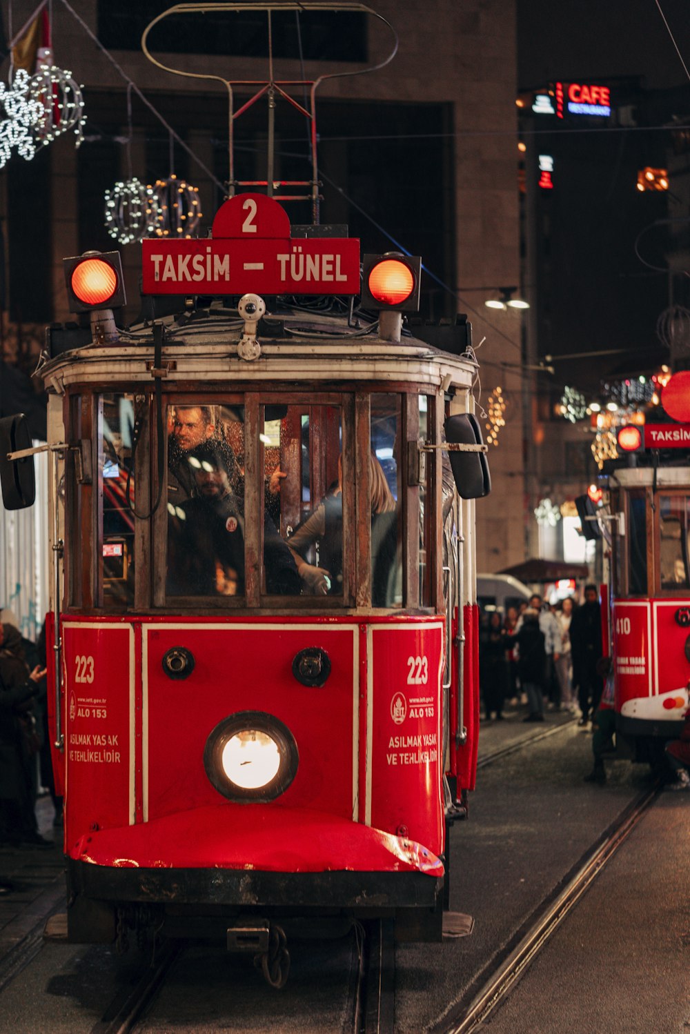 a red trolley car traveling down a street at night