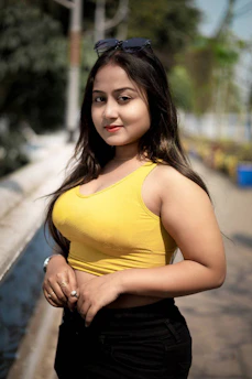 a woman in a yellow tank top posing for a picture