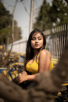 a woman in a yellow top sitting on a bench
