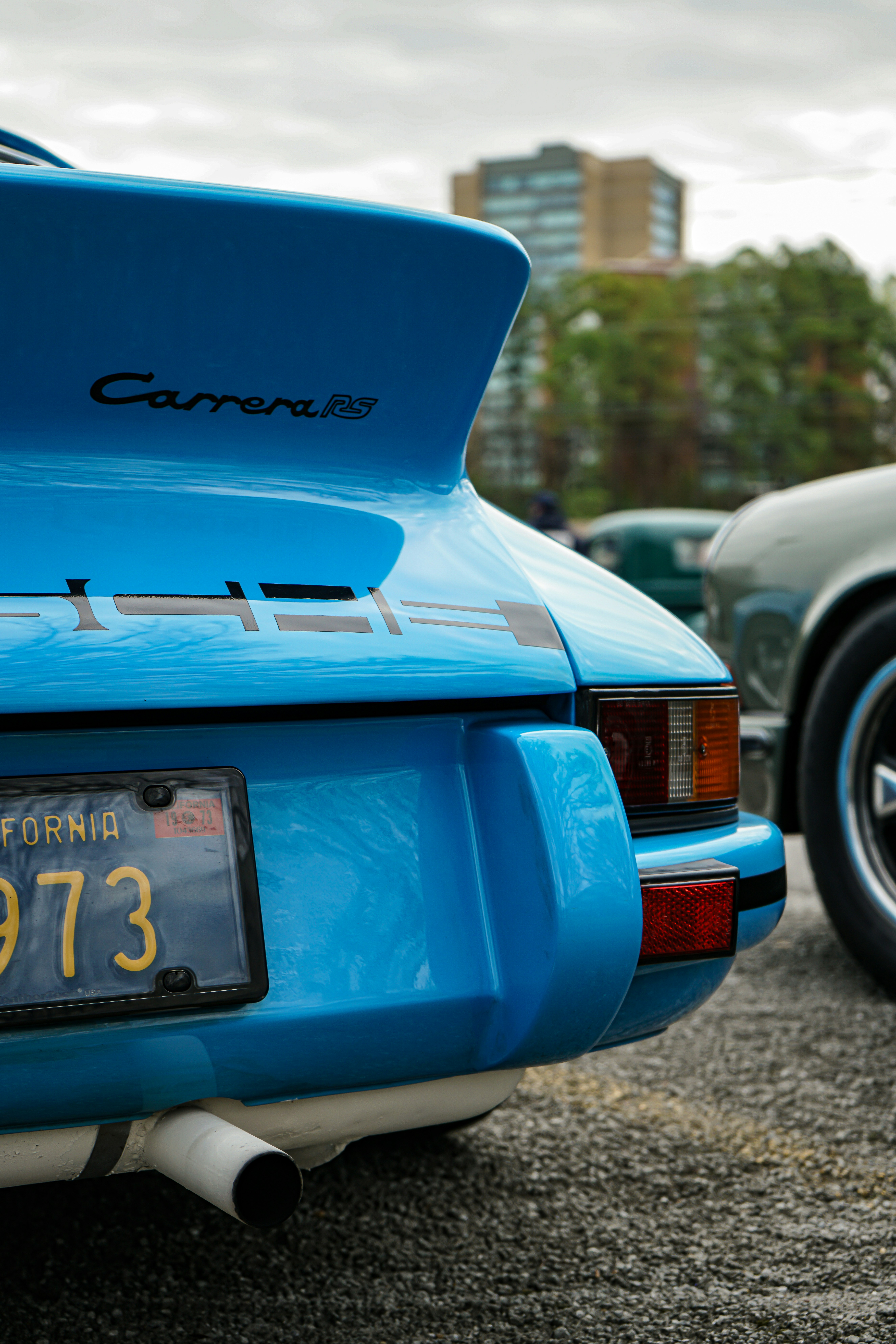 a blue car parked in a parking lot next to other cars