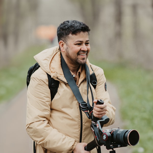 A photographer holding his camera and smiling