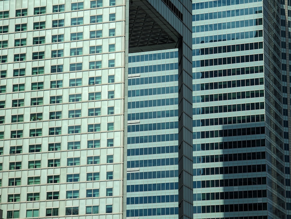 a plane flying in front of a very tall building