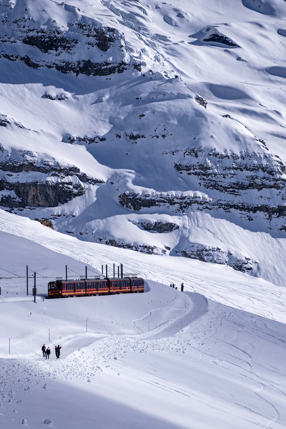 um trem viajando por um lado coberto de neve da montanha