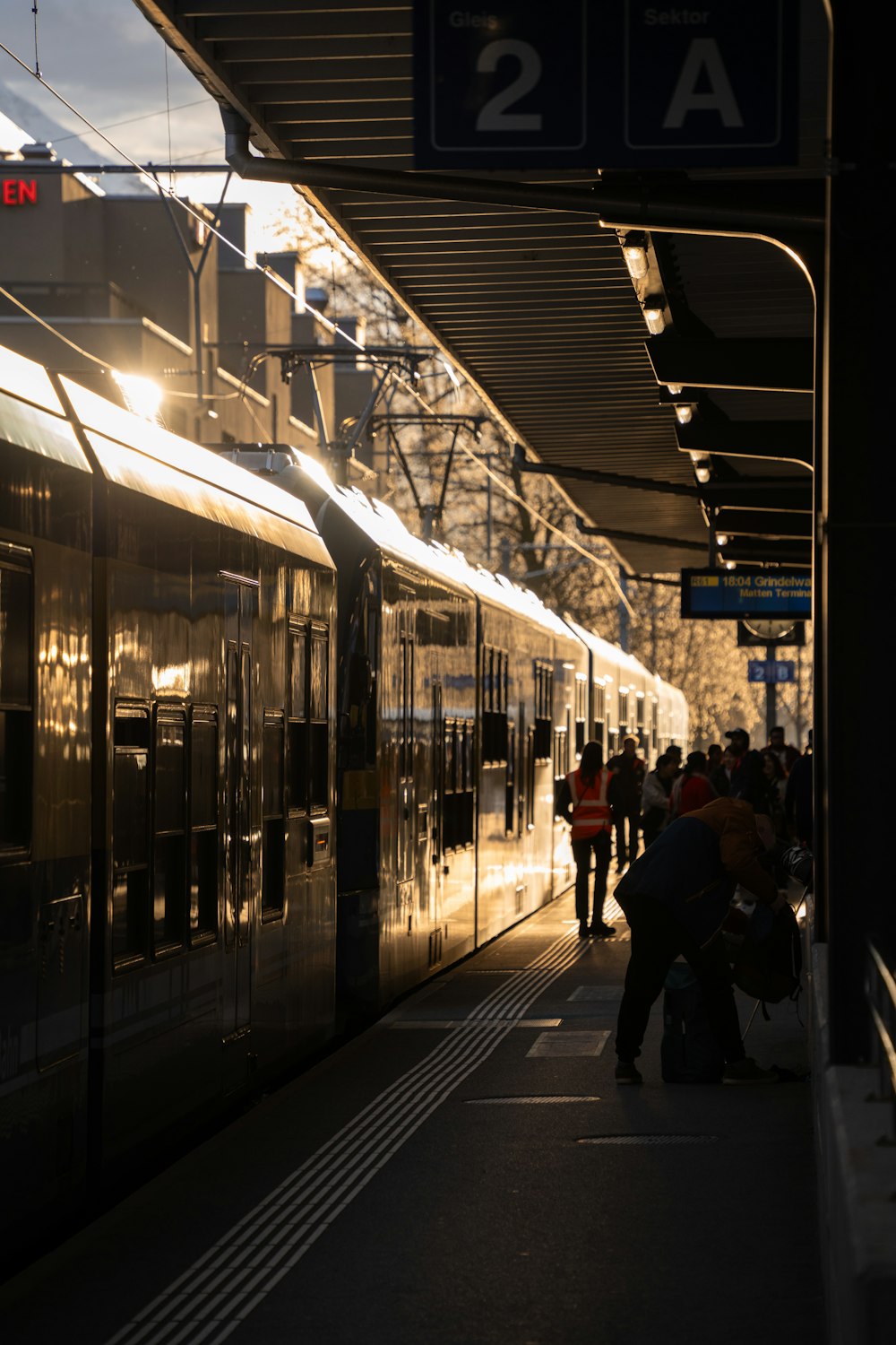 a group of people standing next to a train at a train station