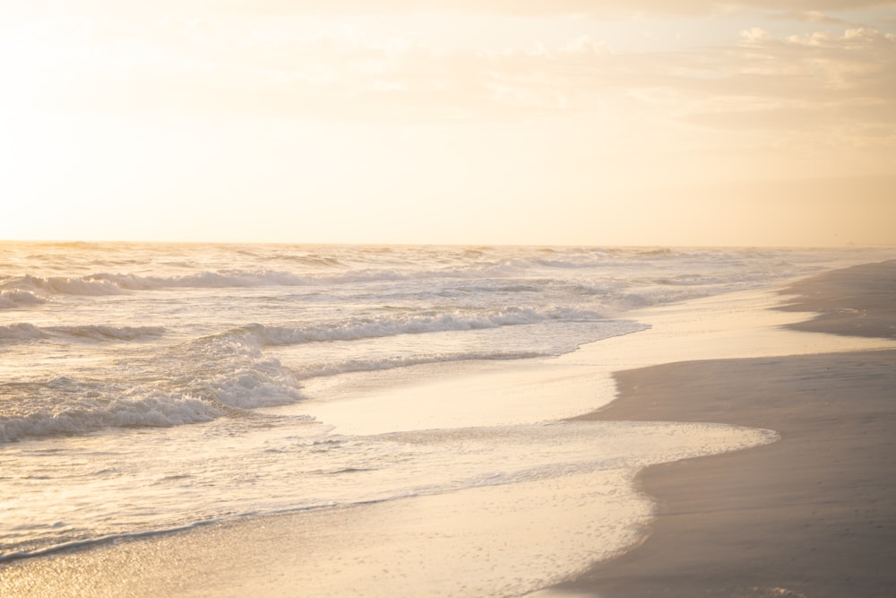 a person walking along the beach with a surfboard