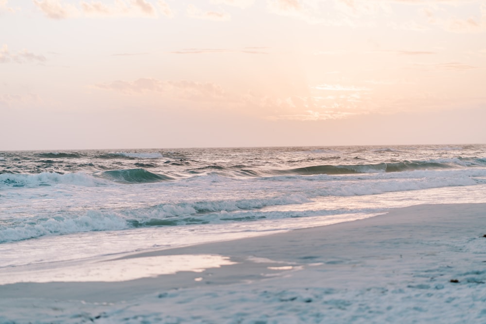 a person walking on the beach with a surfboard