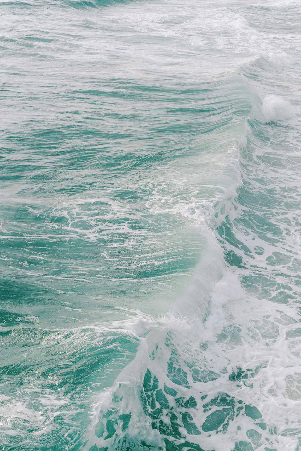 a man riding a surfboard on top of a wave in the ocean