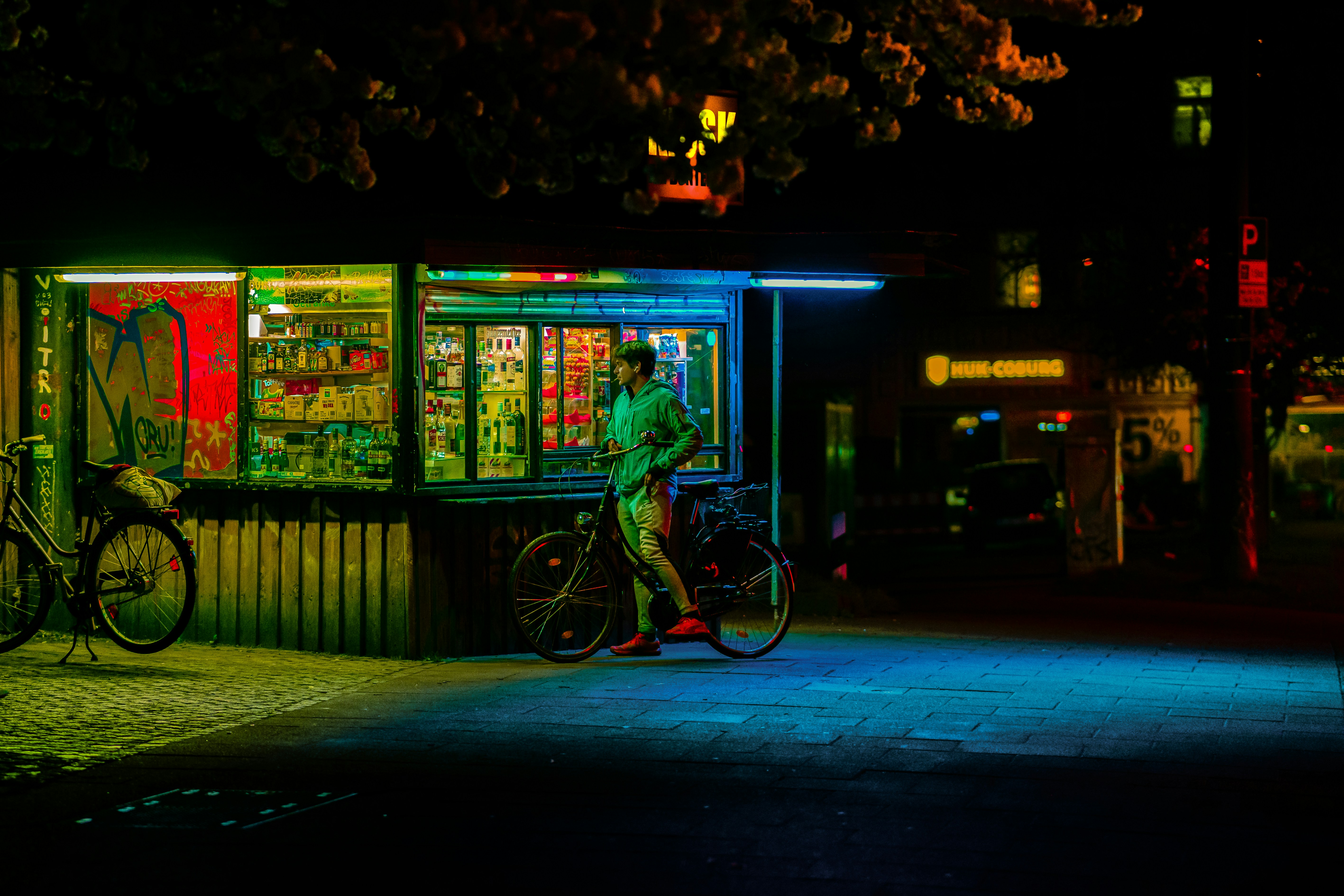 a man standing next to a bike in front of a vending machine, 