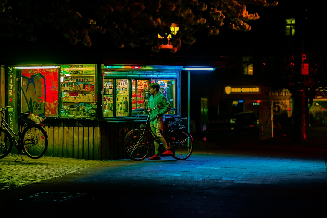 a man standing next to a bike in front of a vending machine,