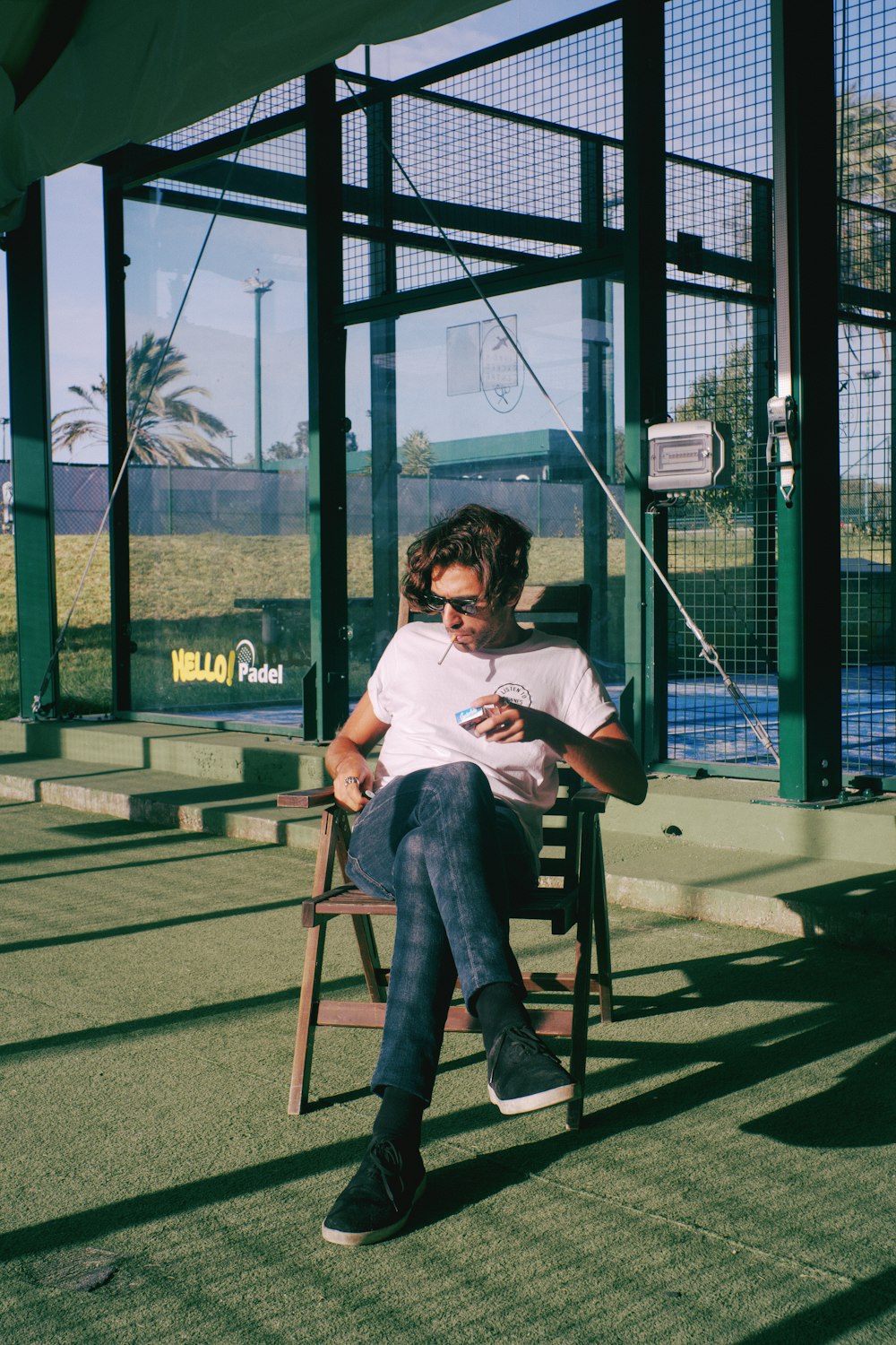 a man sitting in a chair looking at his cell phone