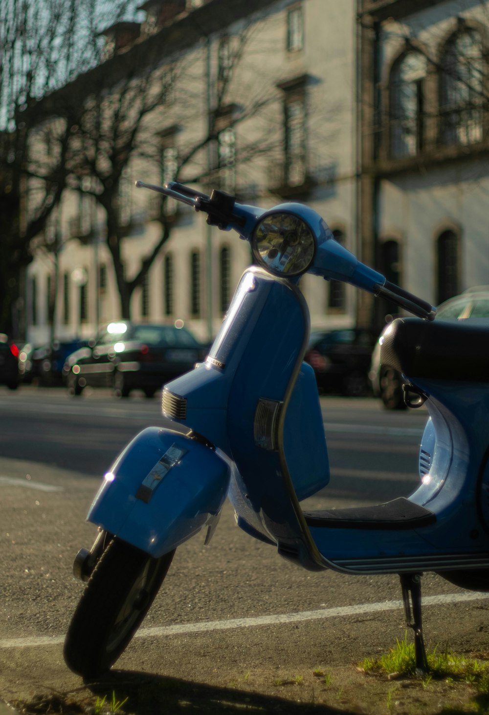 a blue scooter parked on the side of the road