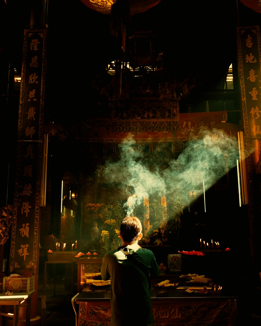 a person standing in a dark room with smoke coming out of it