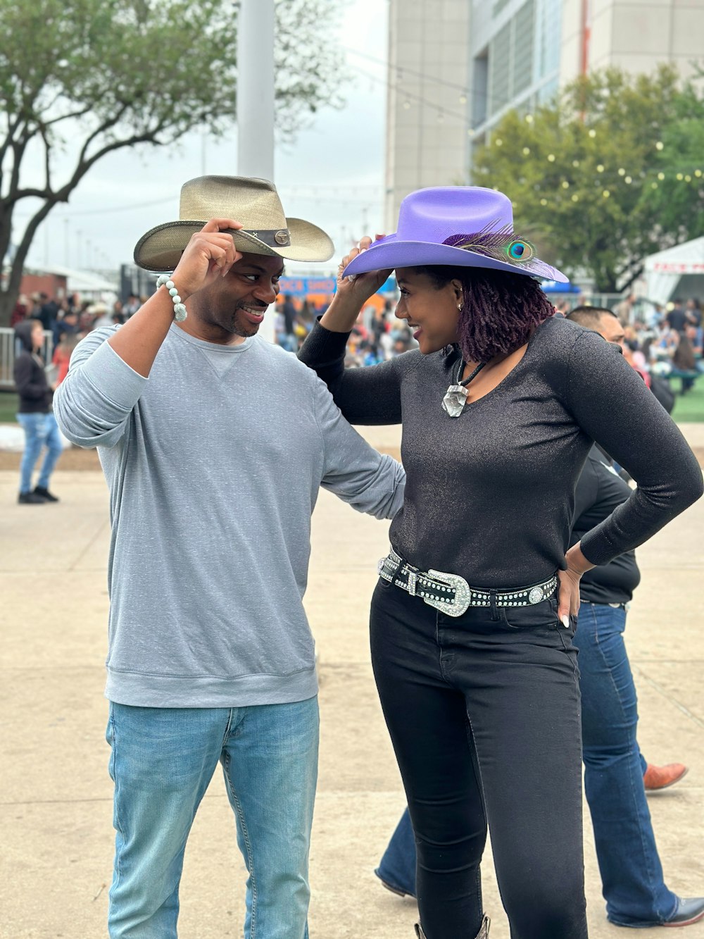 a man standing next to a woman wearing a purple hat