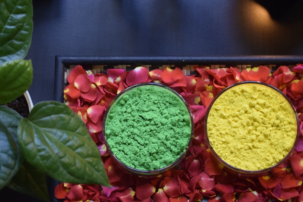 two bowls filled with green and yellow powder