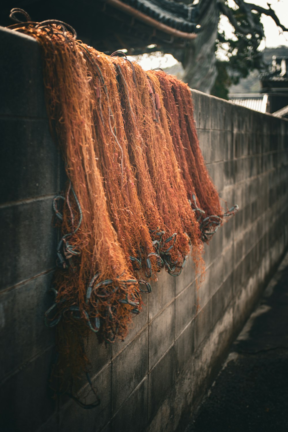 a bunch of orange yarn hanging on a wall