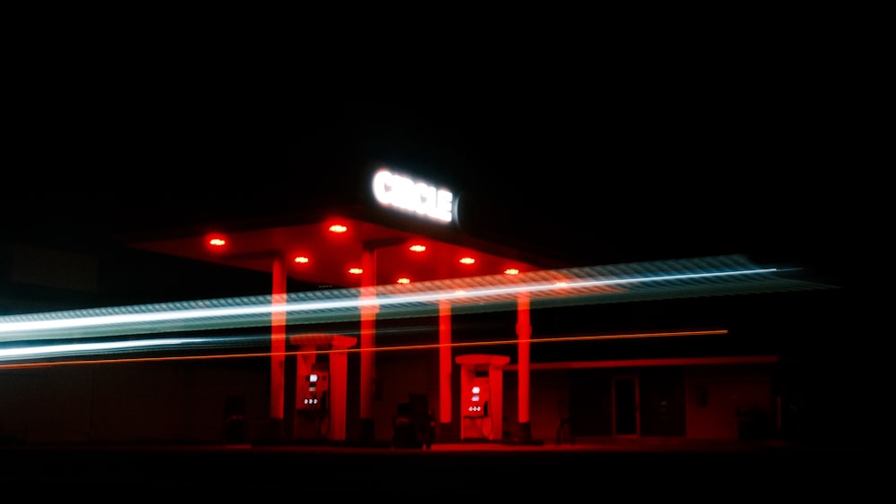 a gas station lit up at night time