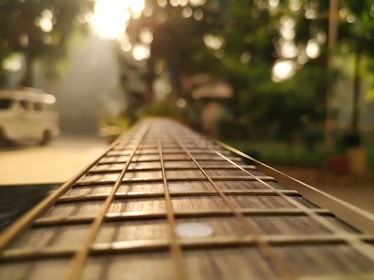 a close up of a guitar string with a car in the background