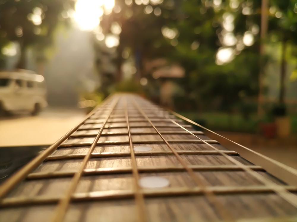 a close up of a guitar string with a car in the background
