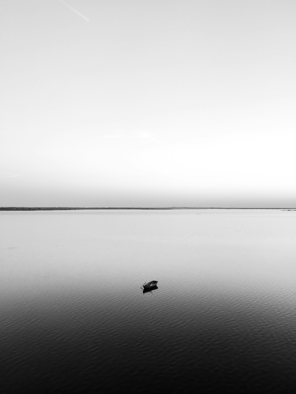 a lone boat floating on a large body of water