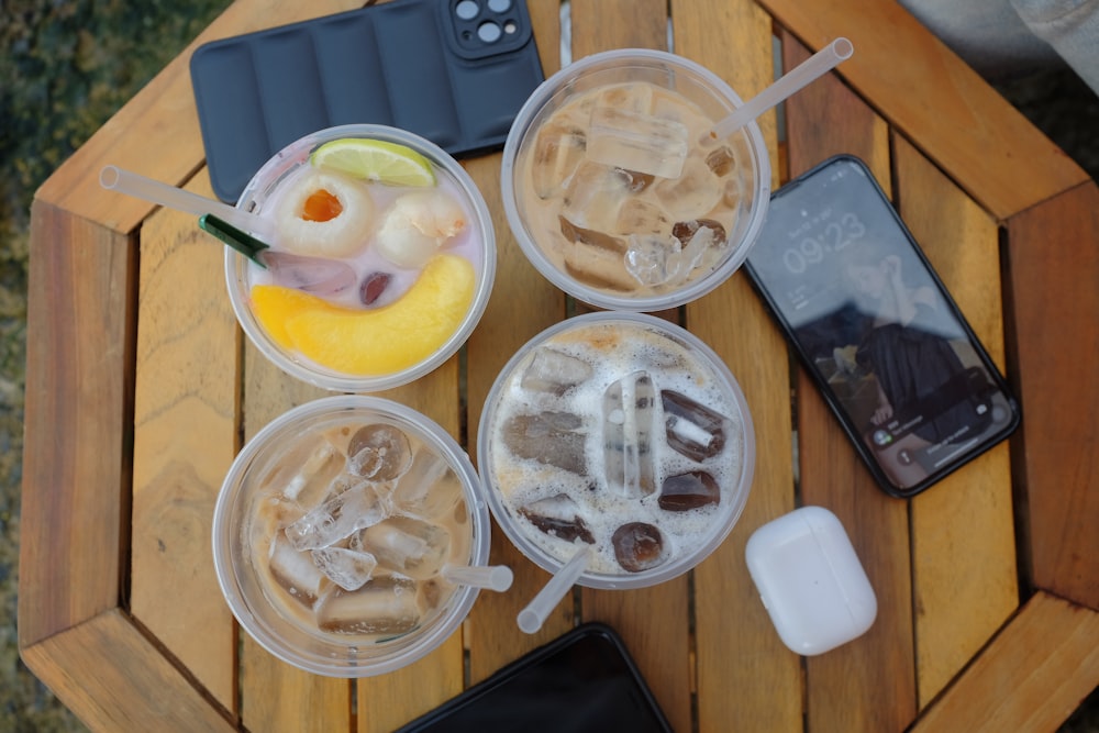 a table topped with three plastic cups filled with drinks