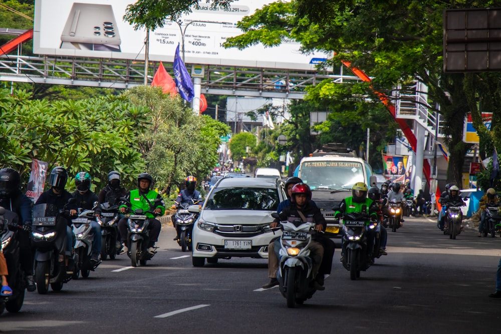 a group of people riding motorcycles down a street