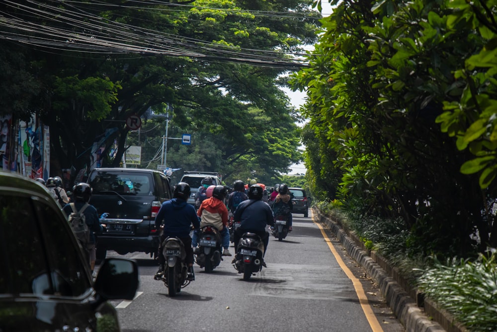 a group of people riding motorcycles down a street