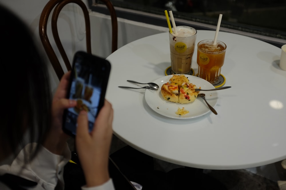 a person taking a picture of food on a table