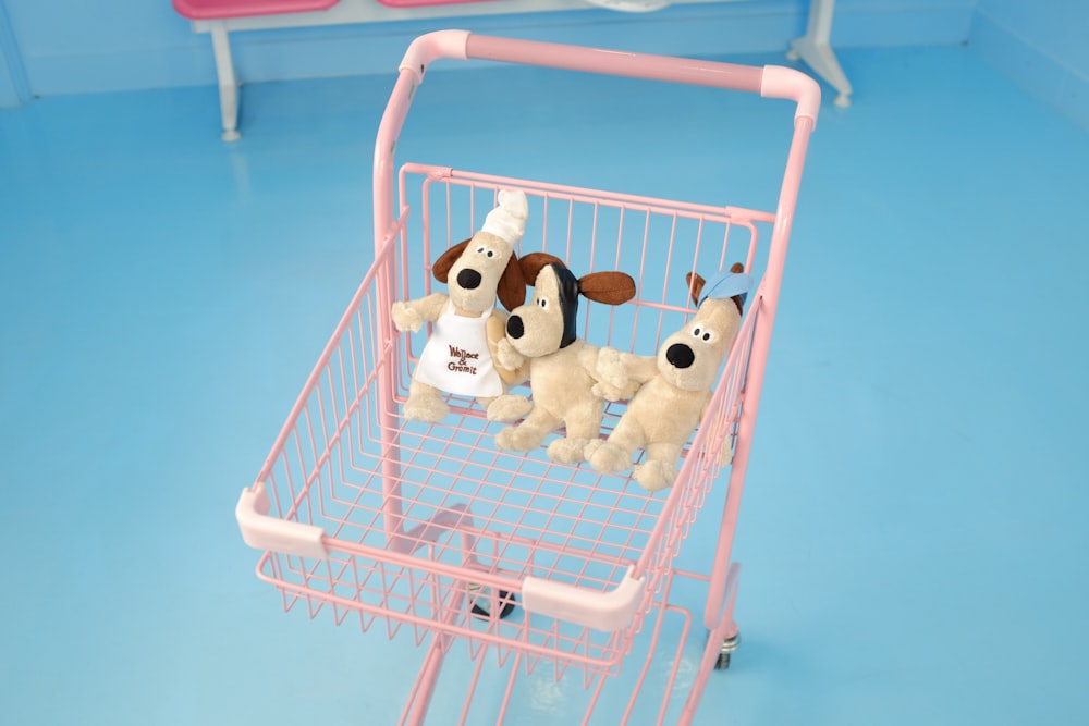 a pink shopping cart filled with stuffed animals