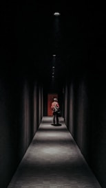 a man sitting on a bench in a dark hallway