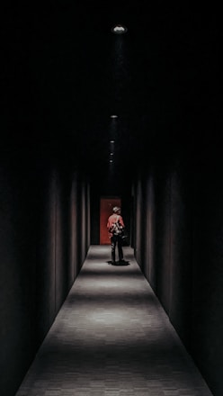 a man sitting on a bench in a dark hallway
