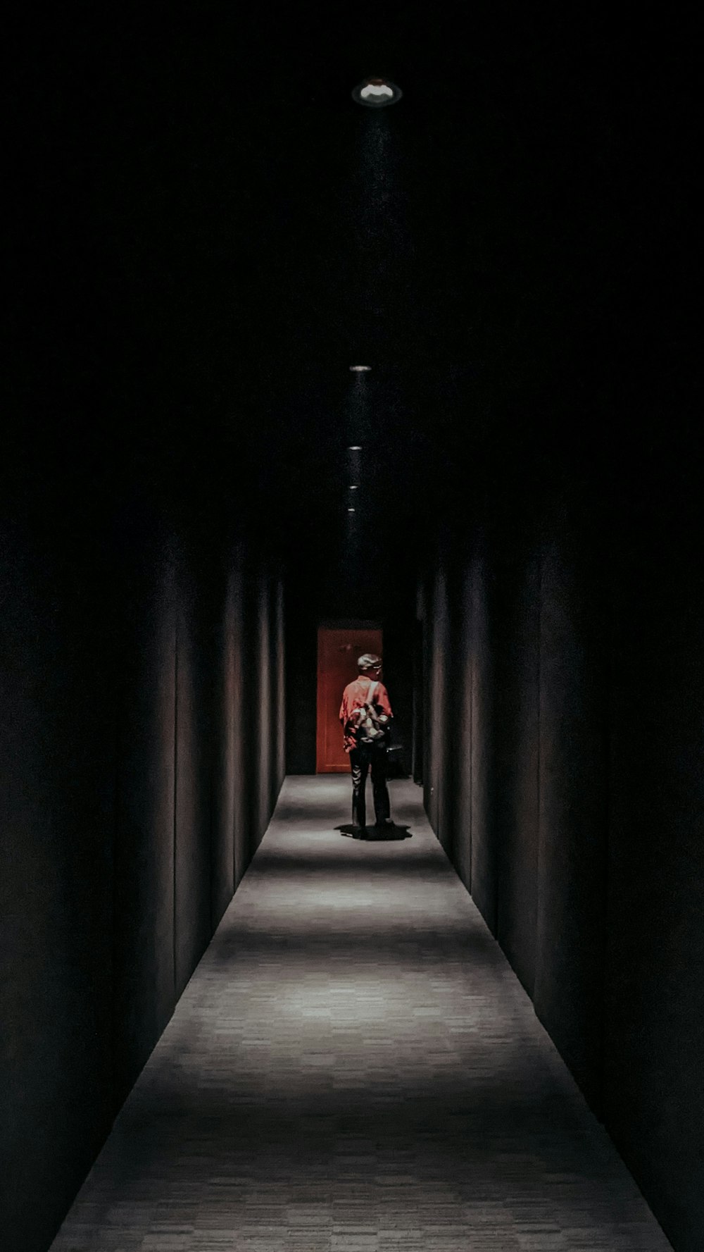 a man sitting on a bench in a dark hallway