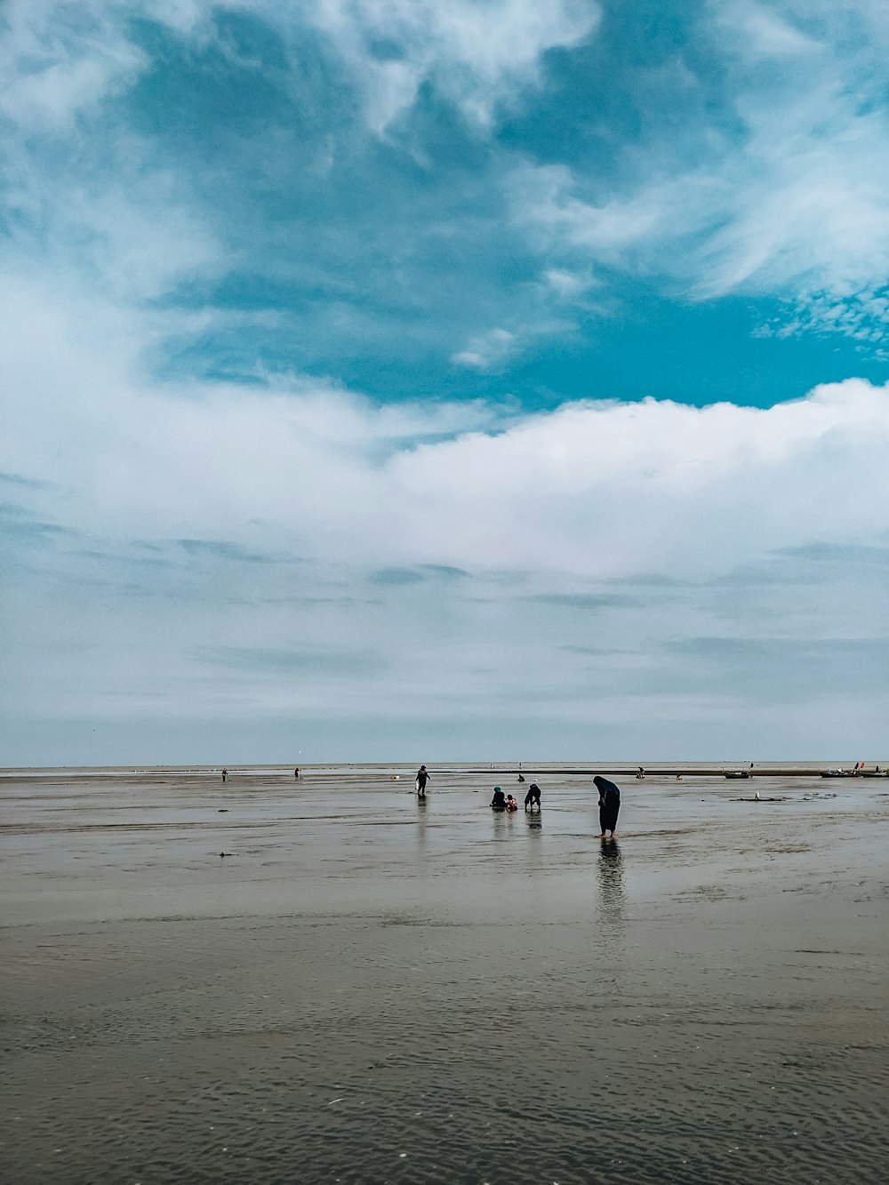 a group of people standing on top of a sandy beach