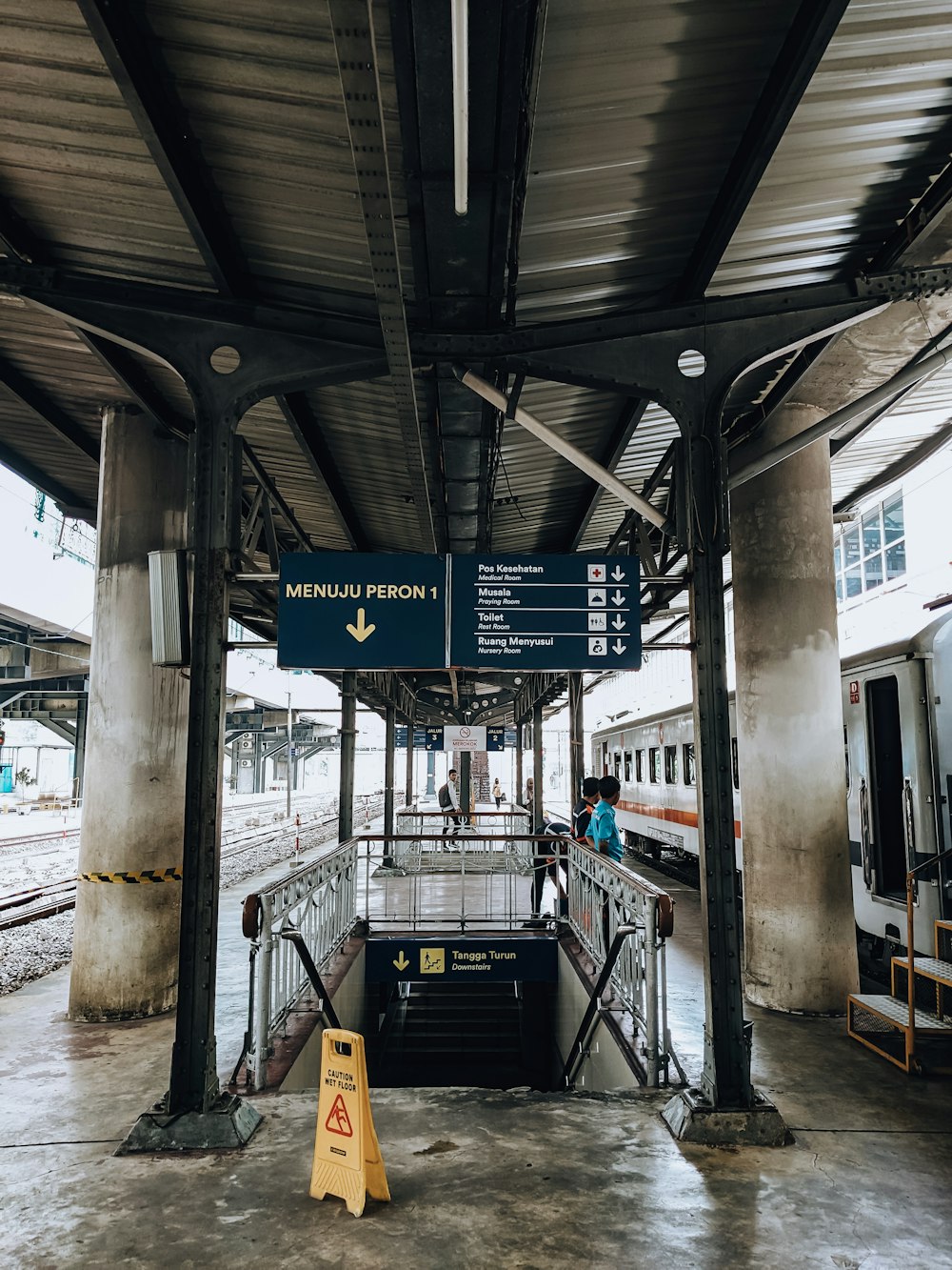 a train station with people waiting for the train