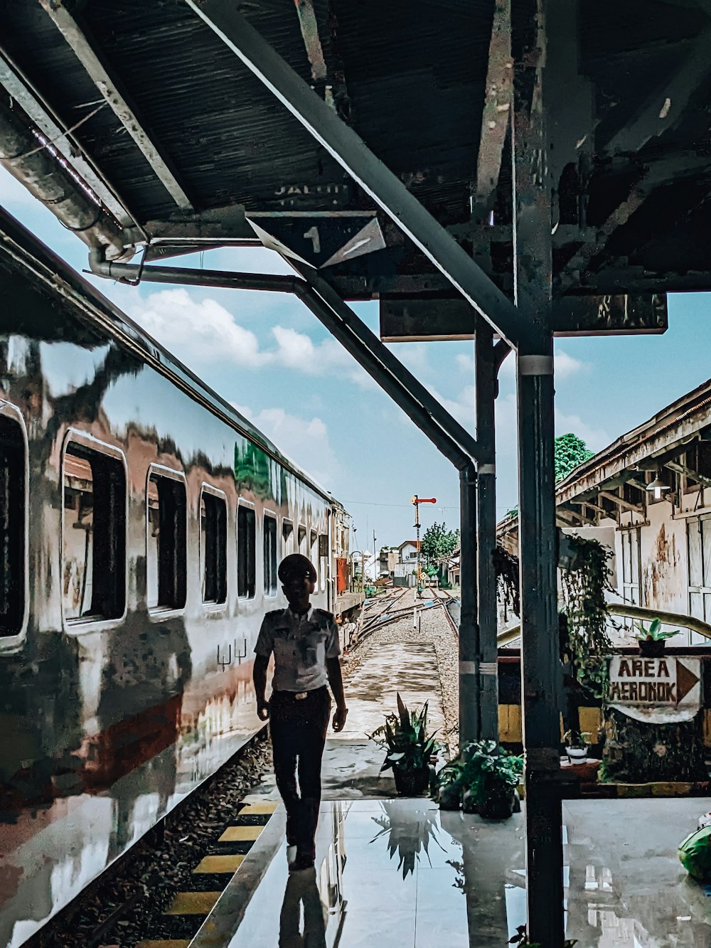 a man walking on a platform next to a train