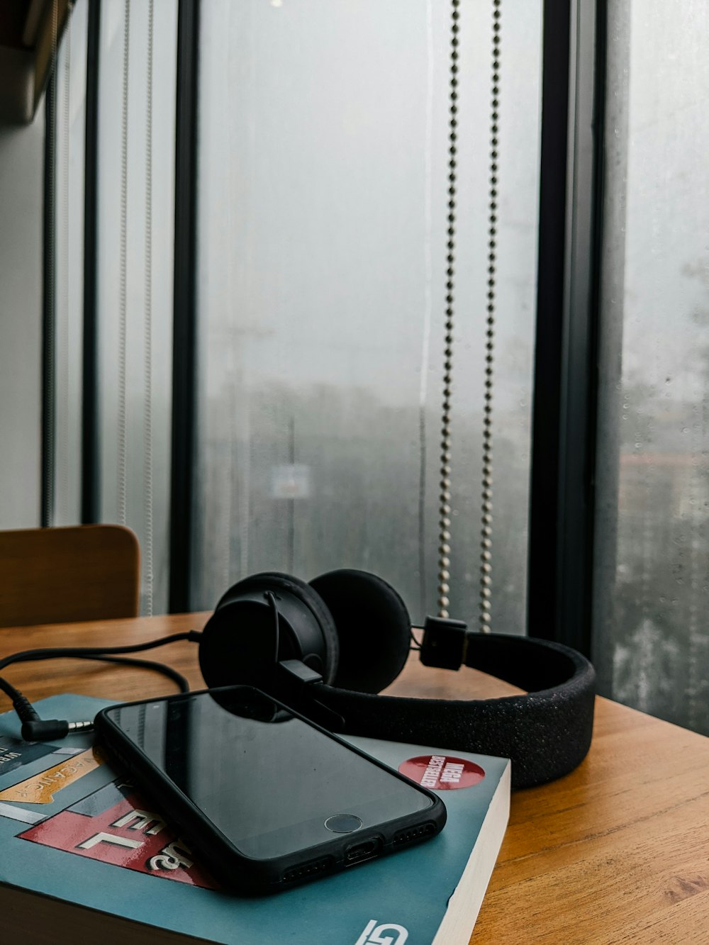 a book, headphones, and cell phone on a table