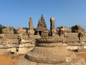 a group of stone statues in front of a blue sky