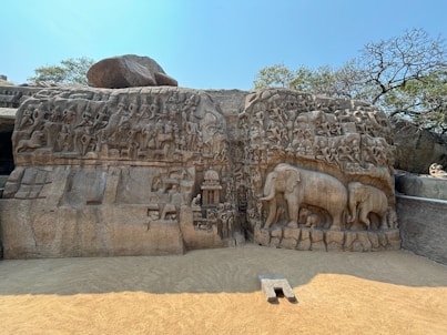 a stone wall with carvings of elephants and people on it