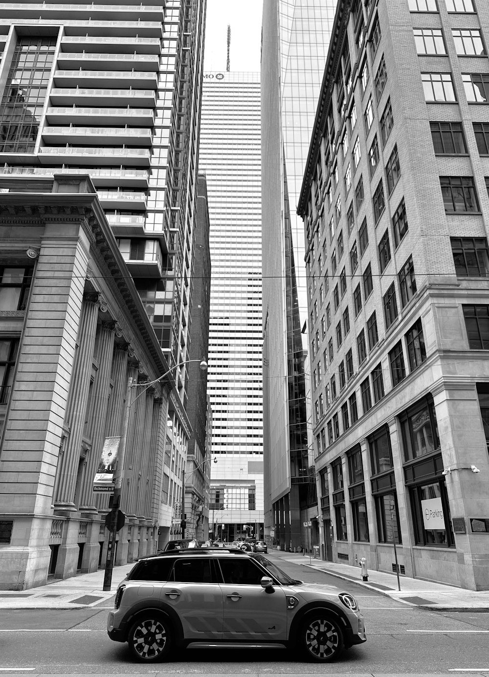 a car driving down a street next to tall buildings