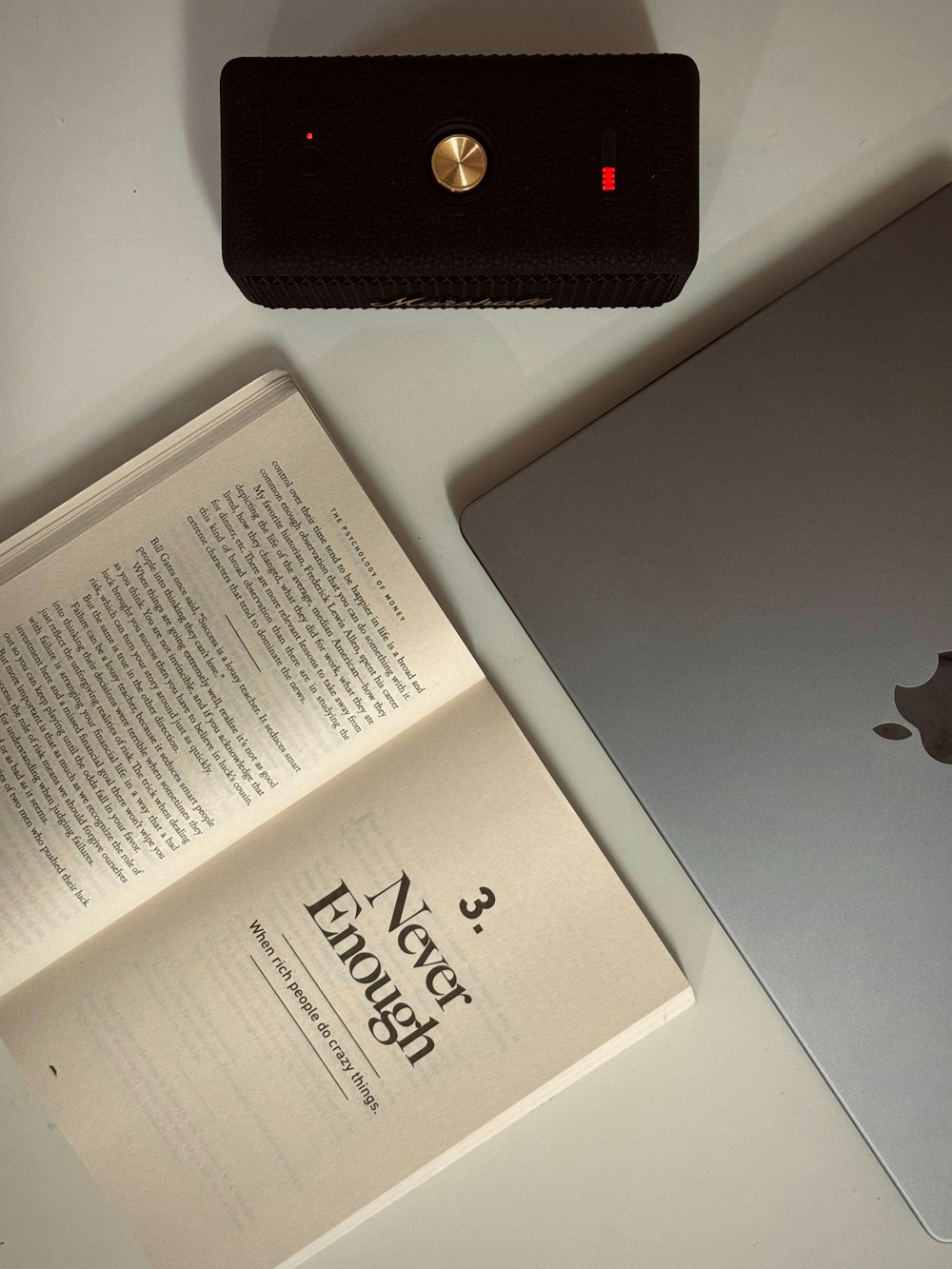 an open book sitting next to an apple laptop