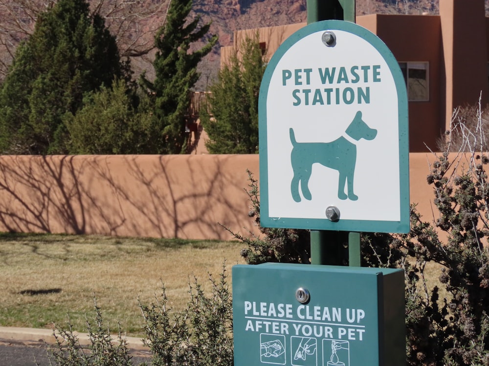 a green and white sign that says pet waste station