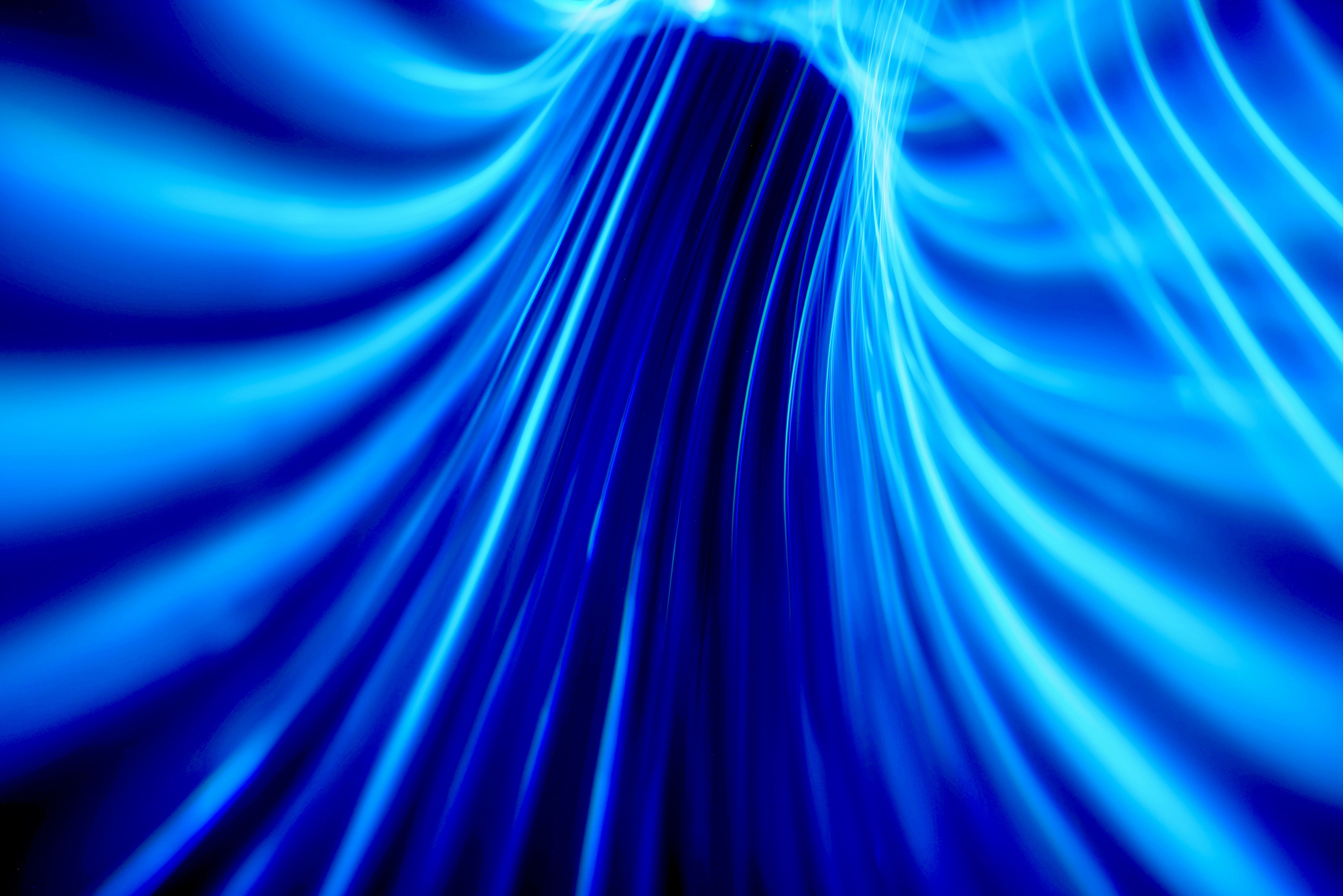 Abstract visualization of glowing blue light trails moving rapidly, representing the concept of zero-latency data flow and instantaneous customer intent.