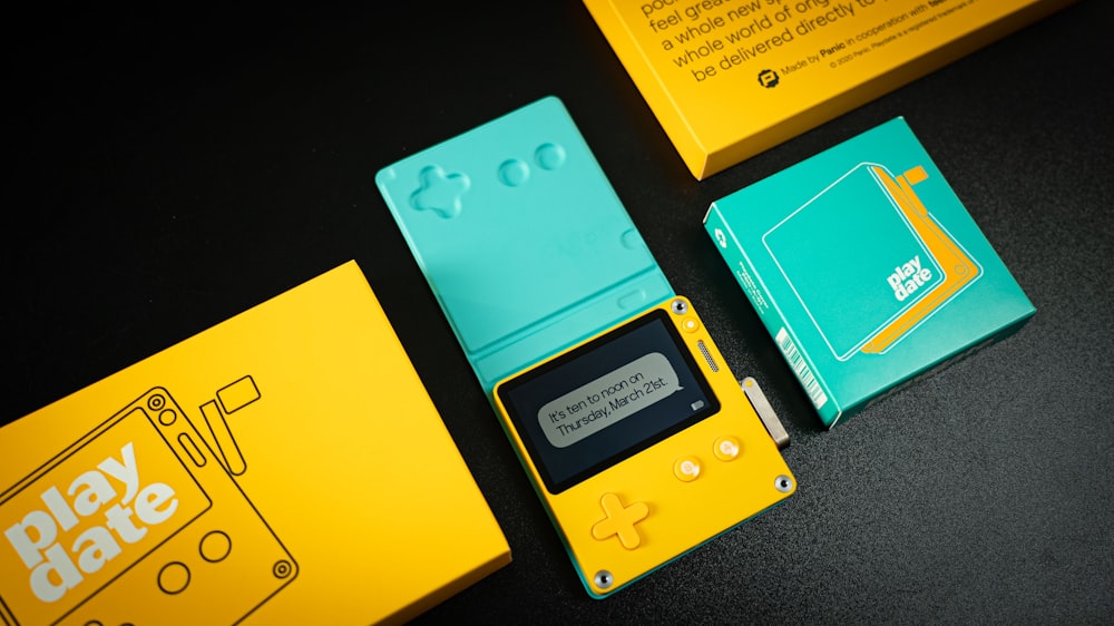 Una scatola gialla e blu con sopra un Gameboy