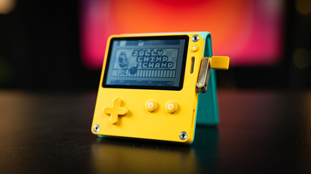 a yellow gameboy sitting on top of a table