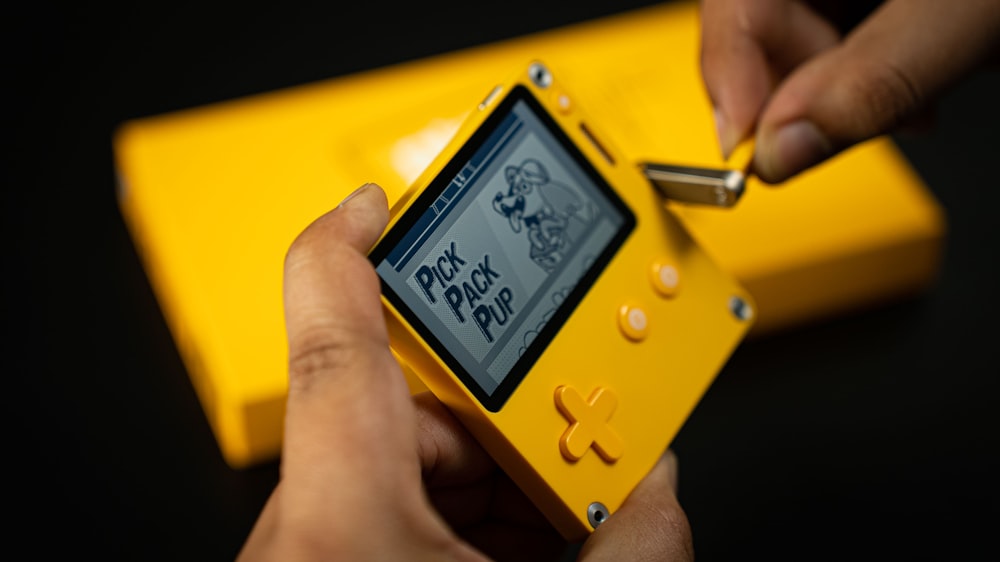 Eine Person spielt ein Spiel auf einem gelben Gerät