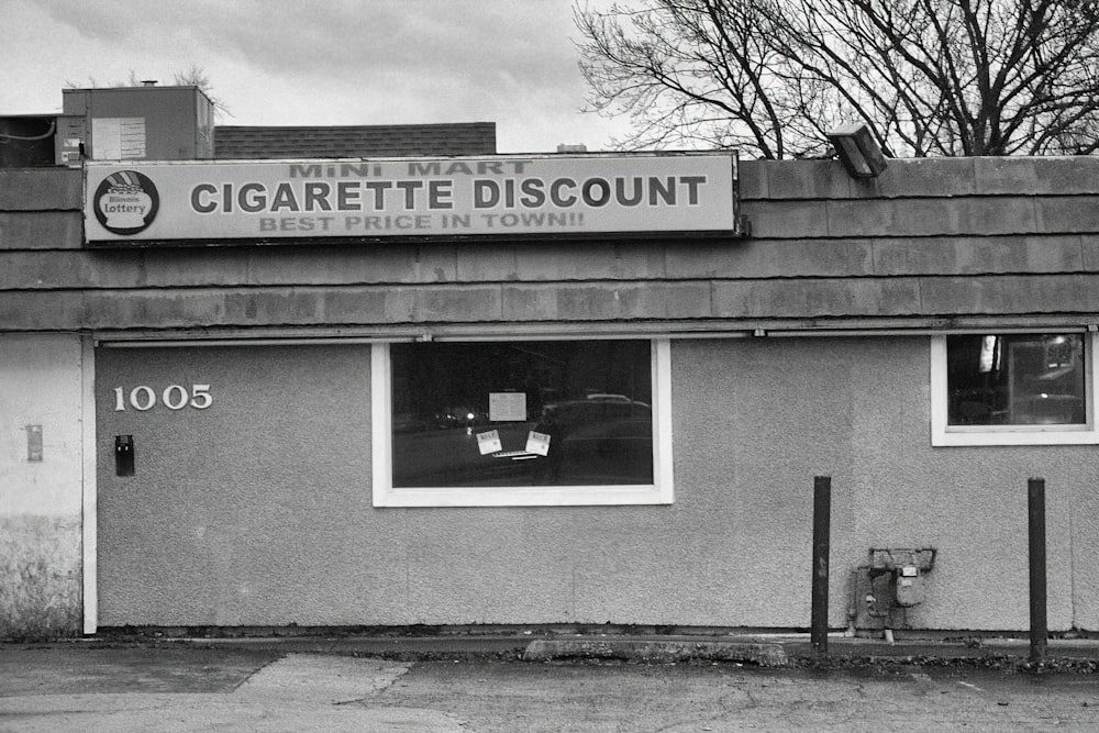 a black and white photo of a cigarette shop