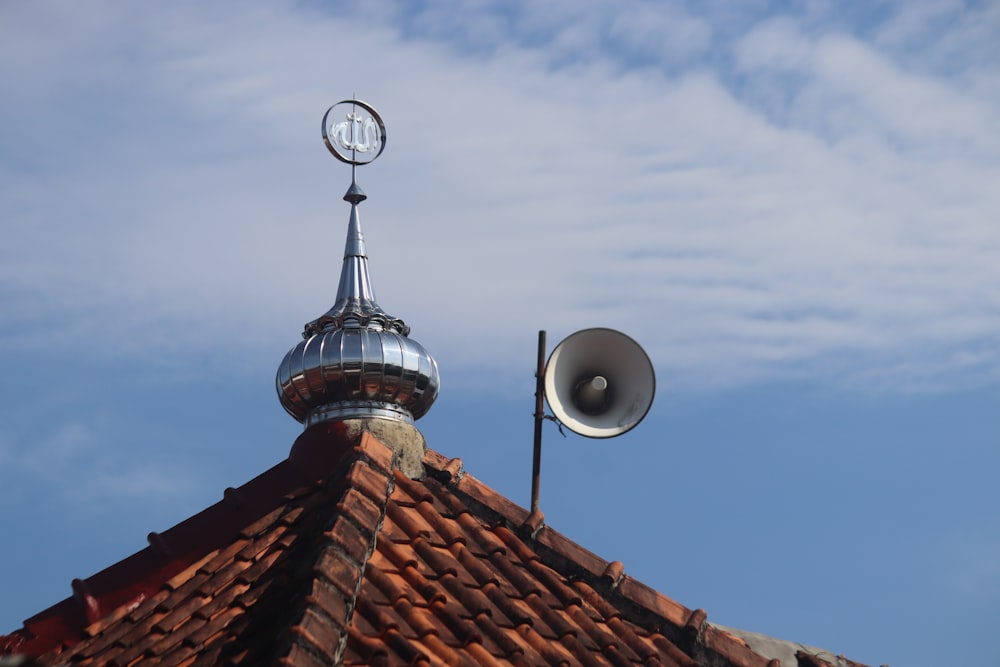 a roof with a weather vane and a satellite dish on top