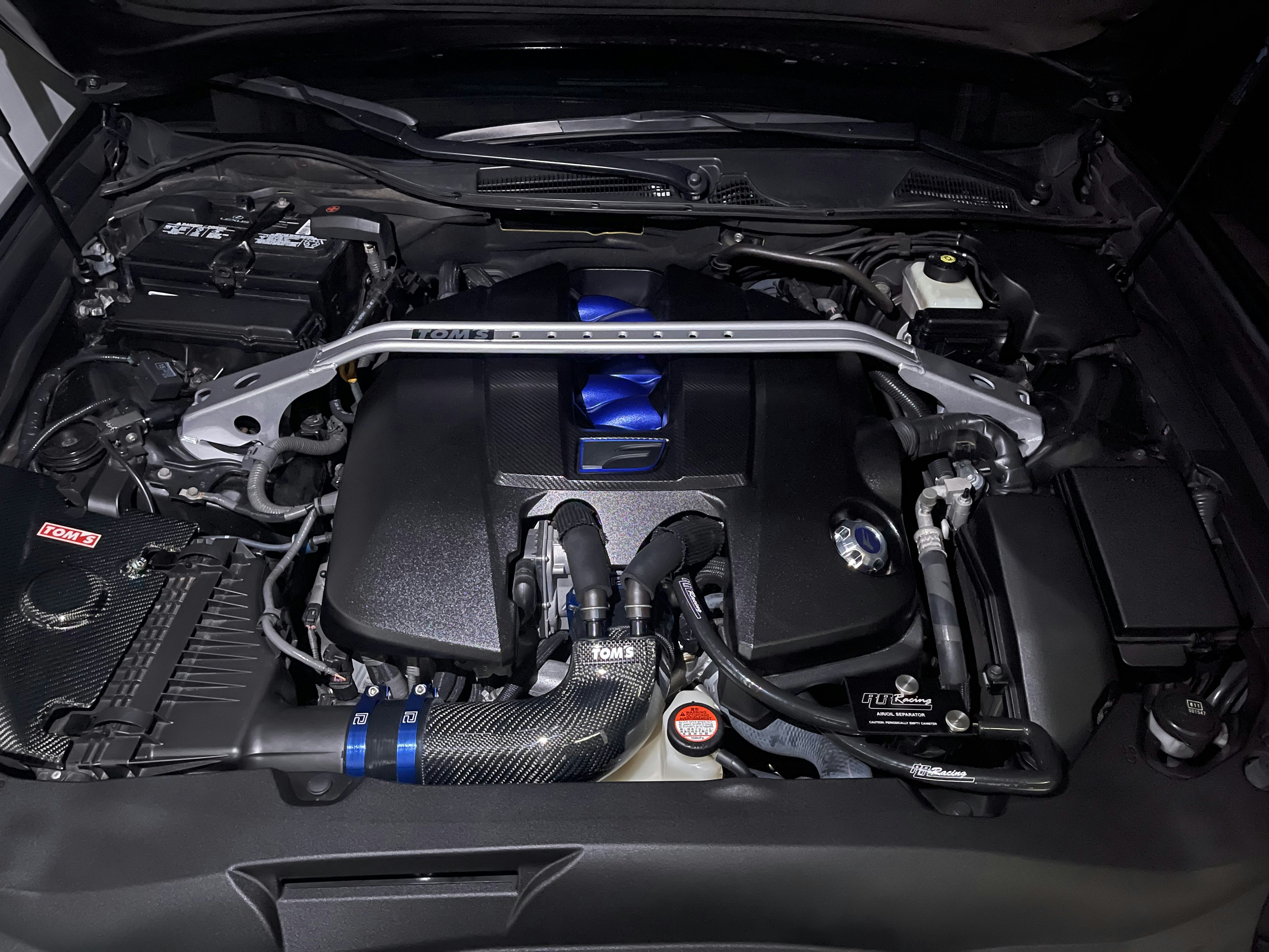Technician using a tablet to diagnose a hybrid vehicle inside an auto repair shop