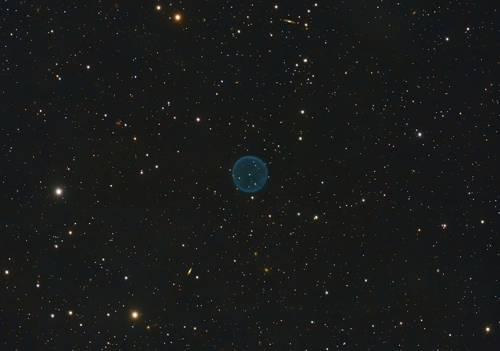 a blue object in the middle of a black sky